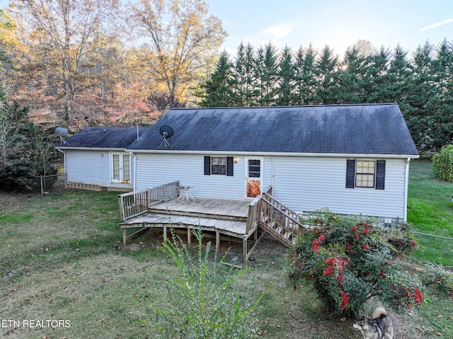 rear view of property with a wooden deck and a yard