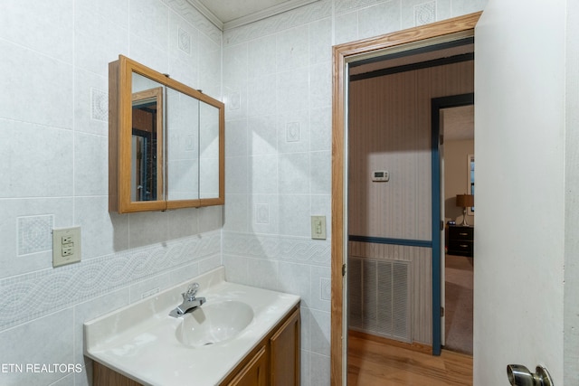 bathroom featuring vanity, wood-type flooring, and tile walls