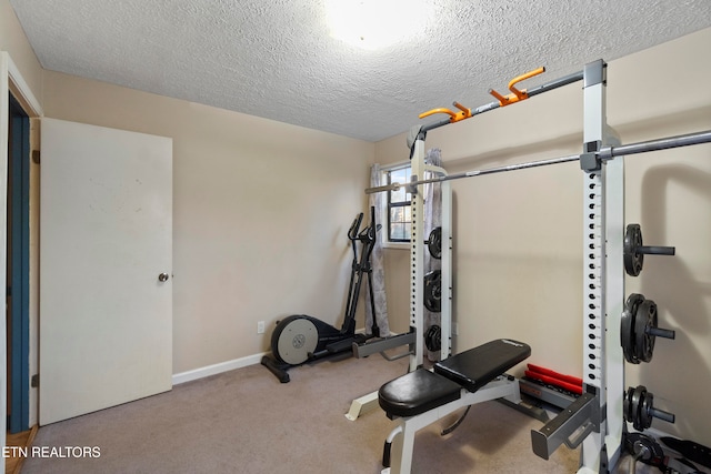 exercise room with light colored carpet and a textured ceiling