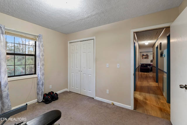 exercise room featuring carpet and a textured ceiling