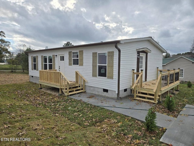 view of front of house with a wooden deck and a front yard