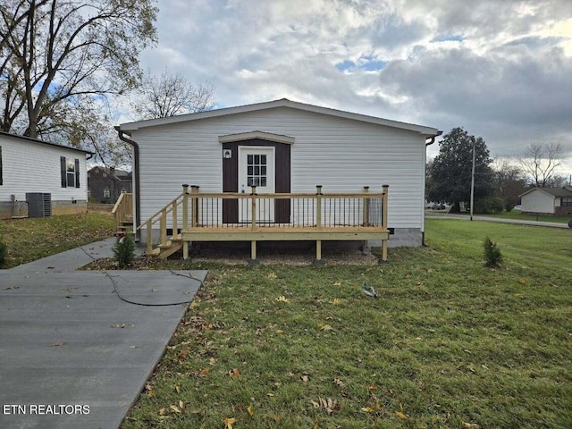 back of house with a yard, a wooden deck, and central AC