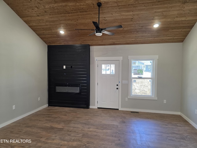 foyer entrance featuring a large fireplace, wood ceiling, vaulted ceiling, and wood finished floors