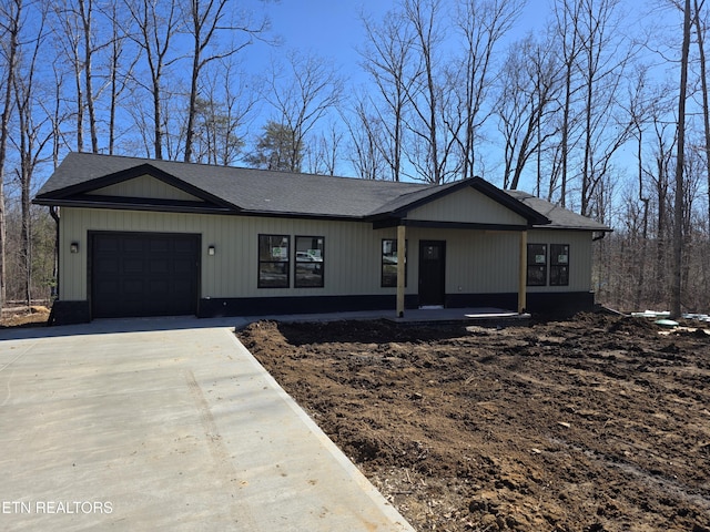 view of front of property featuring a garage, concrete driveway, and a porch