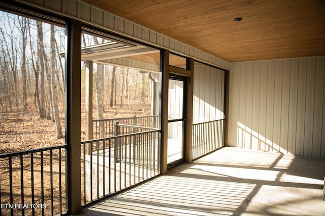 unfurnished sunroom featuring plenty of natural light and wooden ceiling