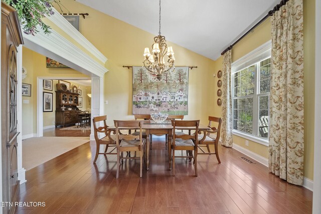 dining space featuring a chandelier, high vaulted ceiling, plenty of natural light, and dark wood-type flooring