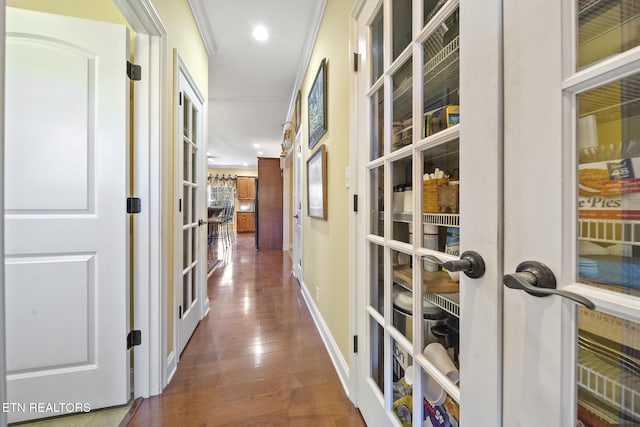 hall featuring wood-type flooring and crown molding