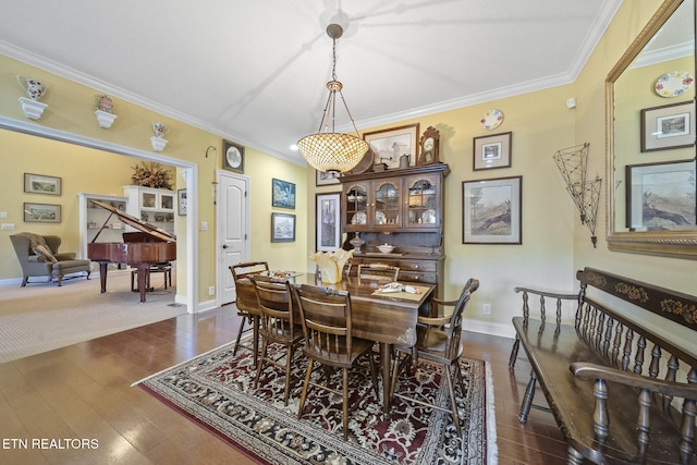 dining space with dark hardwood / wood-style floors and ornamental molding