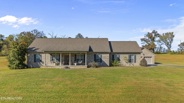 view of front of house with a garage, covered porch, and a front lawn