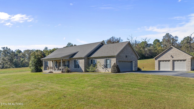 view of front of home featuring a front lawn, covered porch, an outdoor structure, and a garage