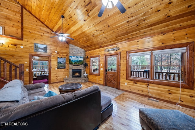 living room featuring wooden walls, plenty of natural light, and light hardwood / wood-style flooring