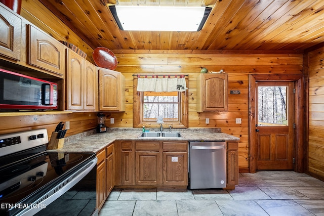 kitchen with wooden walls, a healthy amount of sunlight, and appliances with stainless steel finishes