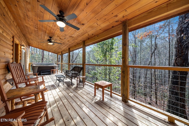 wooden deck with ceiling fan and a hot tub