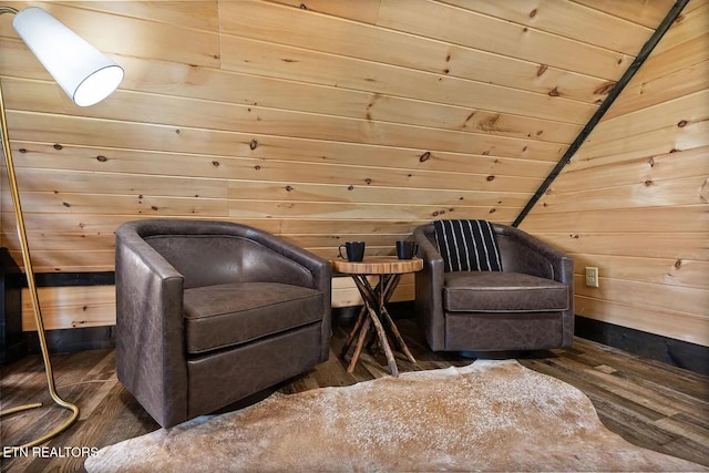 sitting room with lofted ceiling, wooden walls, and dark hardwood / wood-style floors