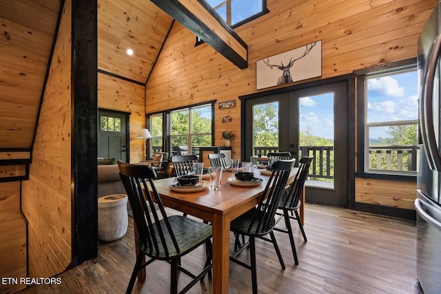 dining room featuring french doors, high vaulted ceiling, beamed ceiling, wooden walls, and hardwood / wood-style flooring