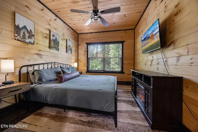 bedroom with wood-type flooring, ceiling fan, and wooden walls