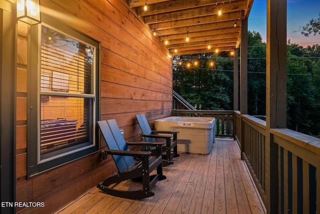 deck at dusk with a hot tub