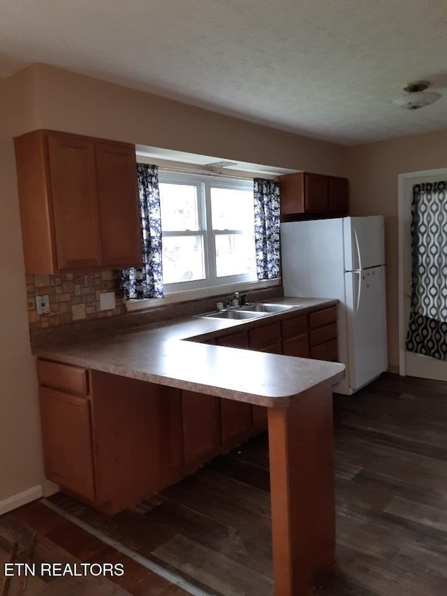 1005 Hollywood Dr, Middlesboro, KY 40965 - kitchen featuring dark hardwood / wood-style floors, kitchen peninsula, sink, and white fridge