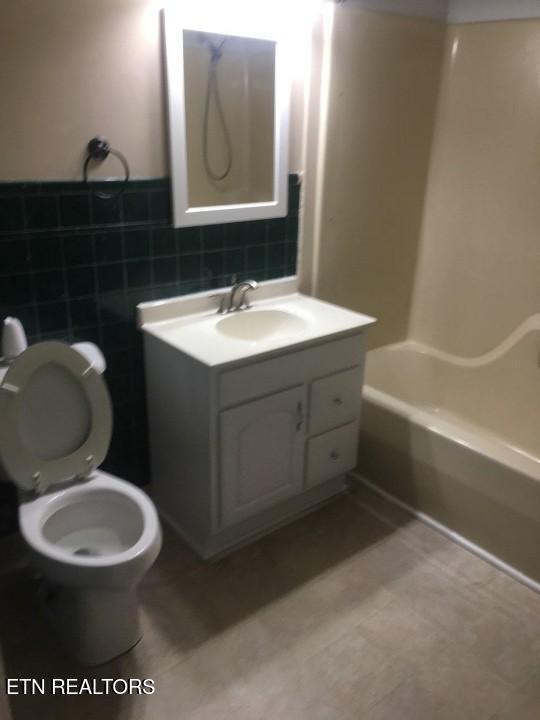 1005 Hollywood Dr, Middlesboro, KY 40965 - full bathroom featuring bathtub / shower combination, vanity, toilet, and tile walls