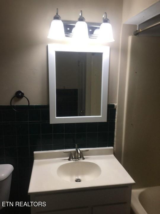 1005 Hollywood Dr, Middlesboro, KY 40965 - bathroom with vanity, toilet, and tile walls