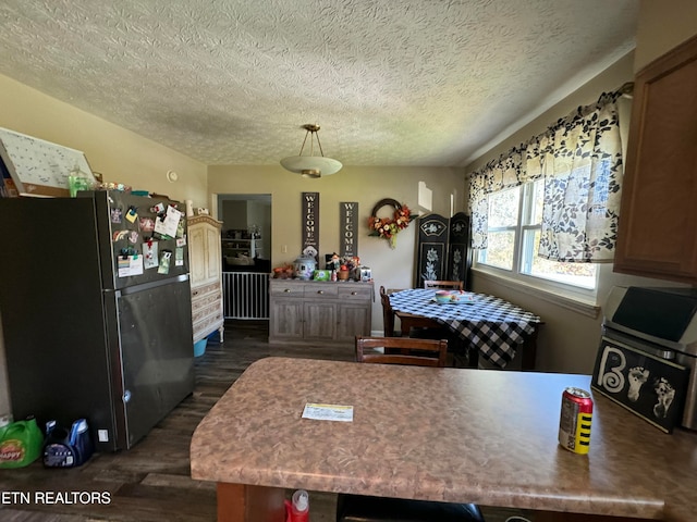 1005 Hollywood Dr, Middlesboro, KY 40965 - kitchen with hanging light fixtures, black refrigerator, a textured ceiling, and dark hardwood / wood-style flooring
