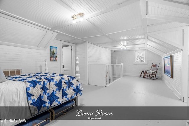 bedroom with lofted ceiling and concrete floors