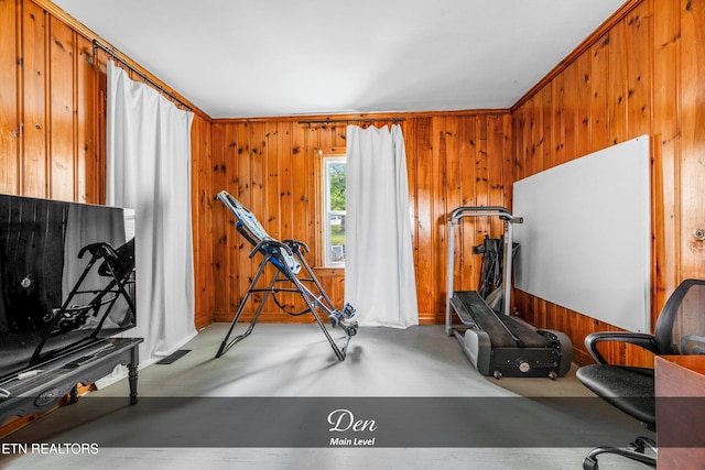 exercise area featuring crown molding and wood walls