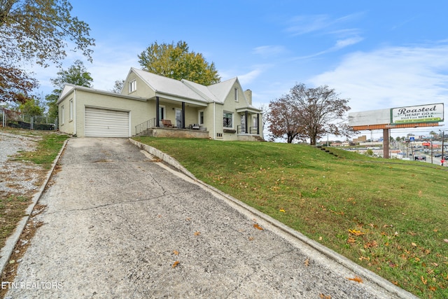 view of front of house with a front yard, a porch, and a garage