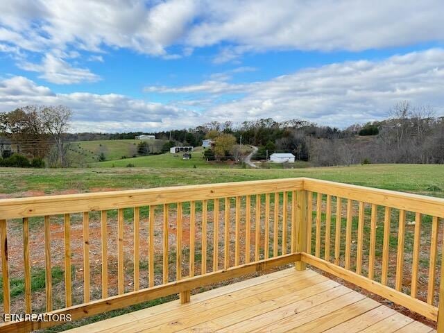 deck featuring a yard and a rural view