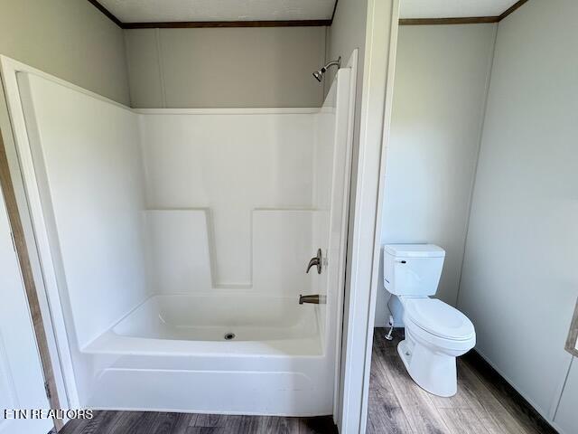 bathroom with crown molding, hardwood / wood-style floors, and toilet