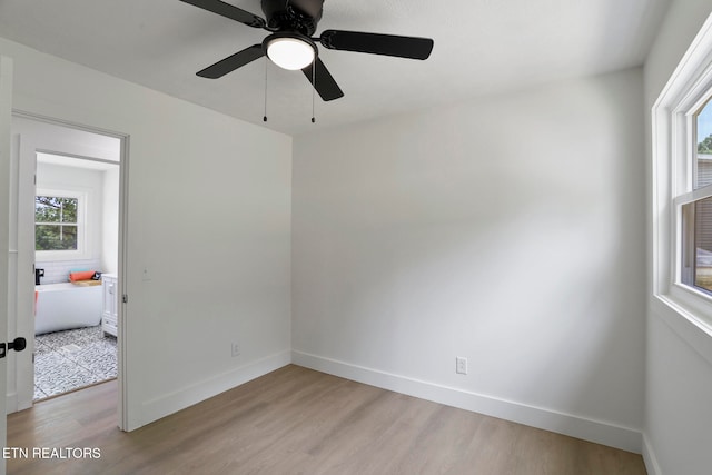 spare room with ceiling fan, plenty of natural light, and light hardwood / wood-style flooring