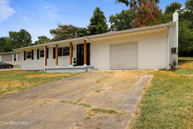 ranch-style house featuring cooling unit, covered porch, a front yard, and a garage