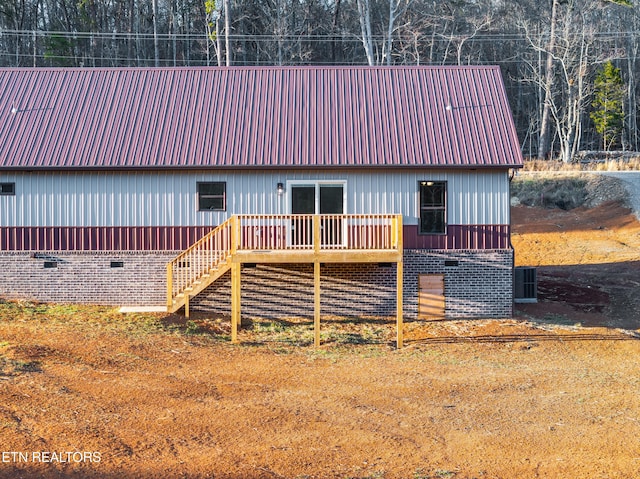 back of house with a wooden deck and central AC