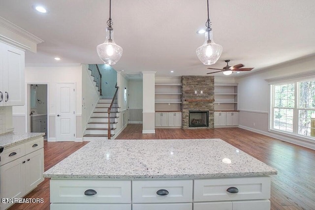 kitchen with hardwood / wood-style floors, hanging light fixtures, and ornamental molding