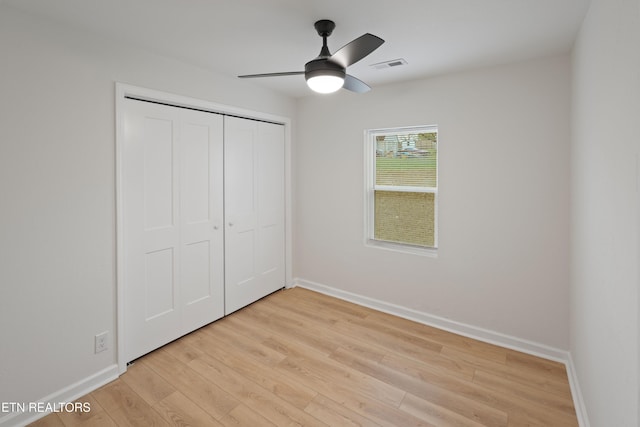 unfurnished bedroom featuring ceiling fan, light hardwood / wood-style floors, and a closet