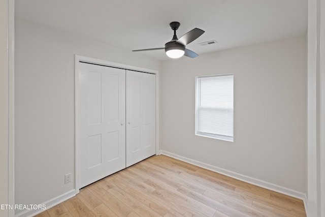 unfurnished bedroom featuring ceiling fan, light wood-type flooring, and a closet