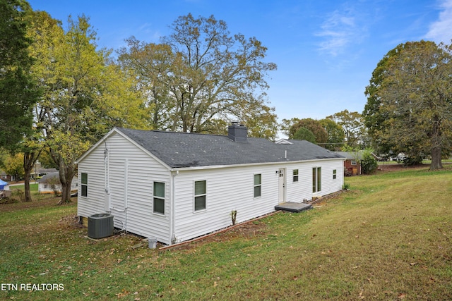 rear view of house with a yard and central AC unit