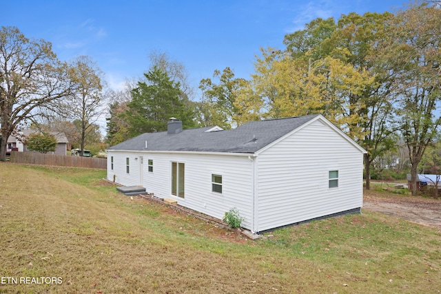 rear view of property with a lawn