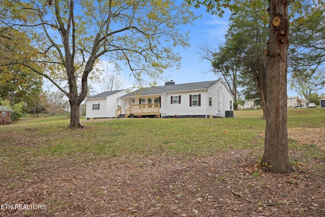 bi-level home with central AC, a wooden deck, and a front lawn