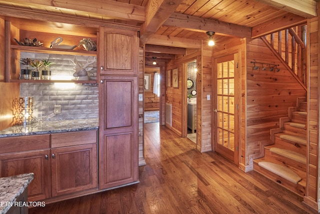 kitchen with dark hardwood / wood-style flooring, wooden ceiling, wooden walls, and dark stone counters