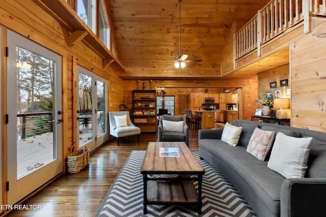 living room featuring hardwood / wood-style flooring, wooden walls, and high vaulted ceiling