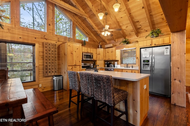 kitchen featuring dark hardwood / wood-style flooring, high vaulted ceiling, wood walls, beamed ceiling, and stainless steel appliances