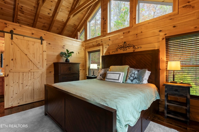 bedroom with wood walls, wooden ceiling, beam ceiling, and a barn door