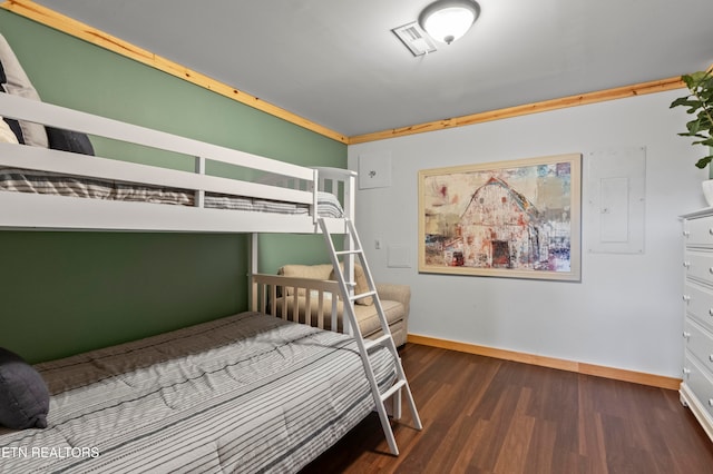 bedroom with electric panel, ornamental molding, and dark hardwood / wood-style flooring