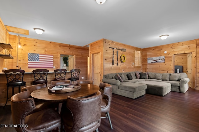 dining room featuring wood walls and dark hardwood / wood-style floors