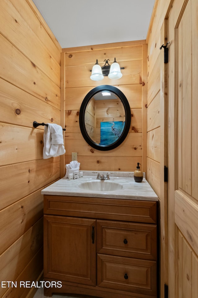 bathroom featuring vanity and wood walls