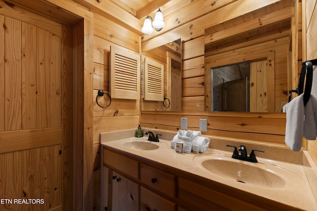 bathroom featuring vanity, beam ceiling, and wooden walls