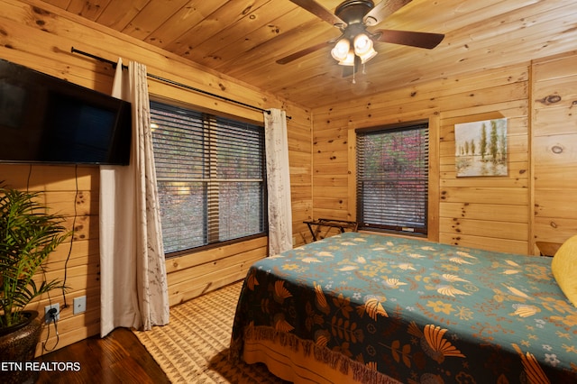 bedroom featuring ceiling fan, wood walls, hardwood / wood-style flooring, and wooden ceiling