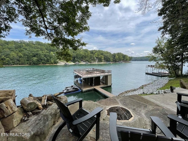 dock area with a fire pit and a water view