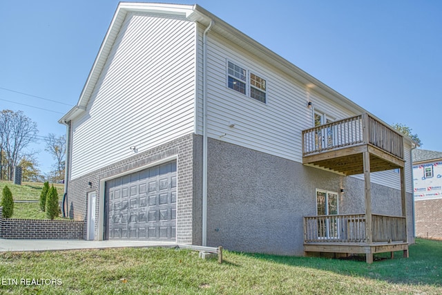 view of home's exterior with a lawn, a wooden deck, and a garage